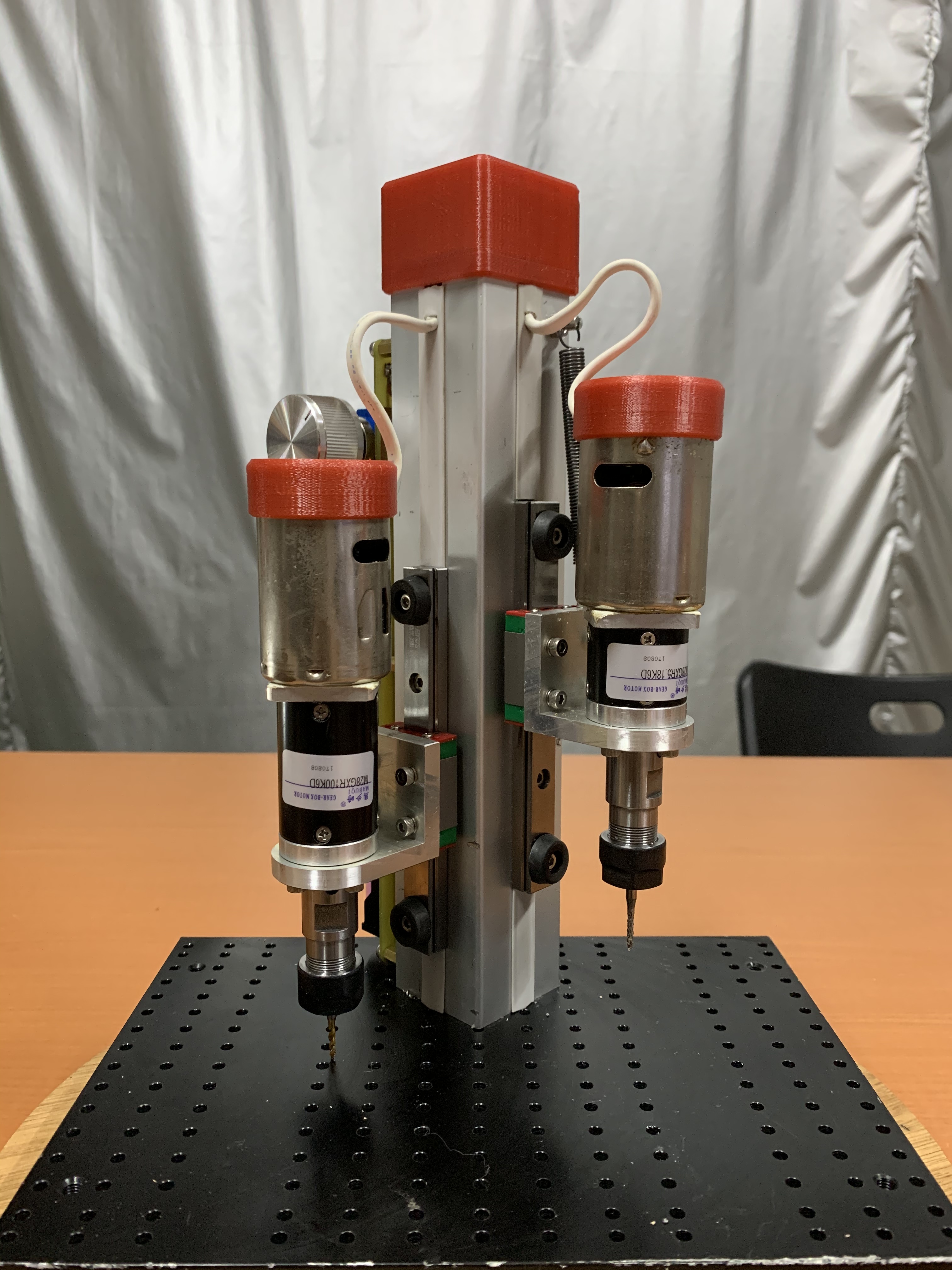 用不同減速比的減速機來搭配，一邊鑽孔，另一邊攻牙。
